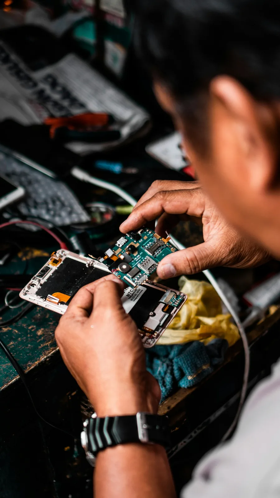 Technician working on a phone logic board at the bench